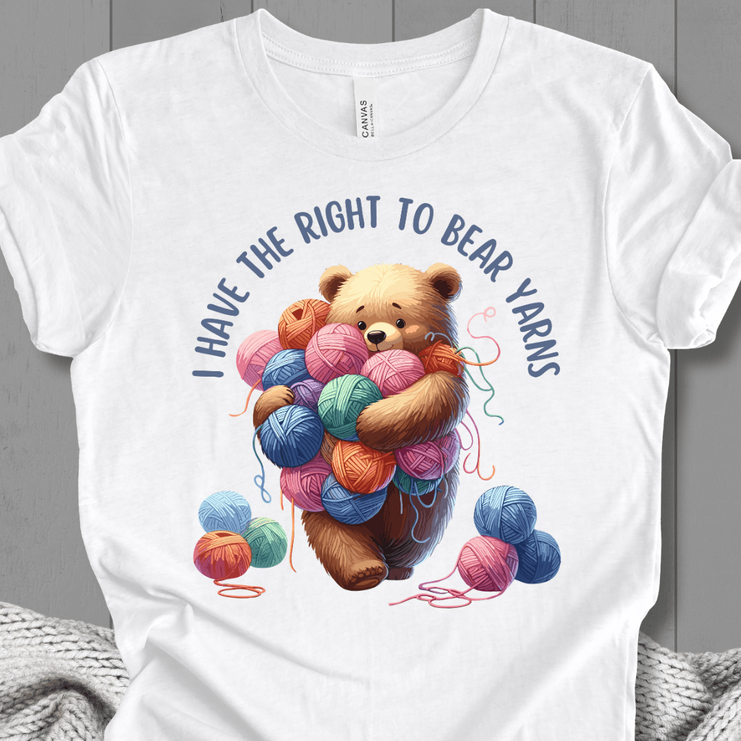 White t-shirt featuring a cute bear holding colorful yarn balls and the phrase 'I Have the Right to Bear Yarns'.