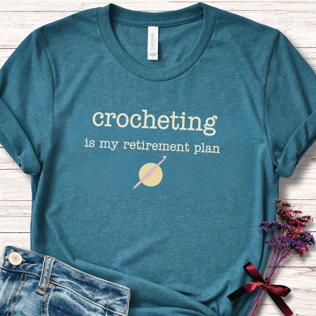 Teal cotton t-shirt with 'crocheting is my retirement plan' graphic design.
