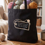 Black tote bag printed with a luggage tag reading If found, return to Barbara. Contains WIPs. Do not frog.