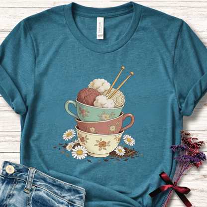 Teal t-shirt with a vintage cup graphic featuring yarn and floral designs, perfect for knitters.