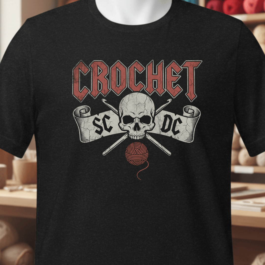 Black crochet t-shirt featuring a skull design, yarn, and hooks, perfect for crochet lovers.