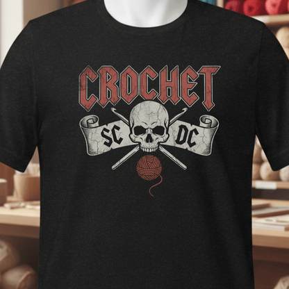 Black crochet t-shirt featuring a skull design, yarn, and hooks, perfect for crochet lovers.