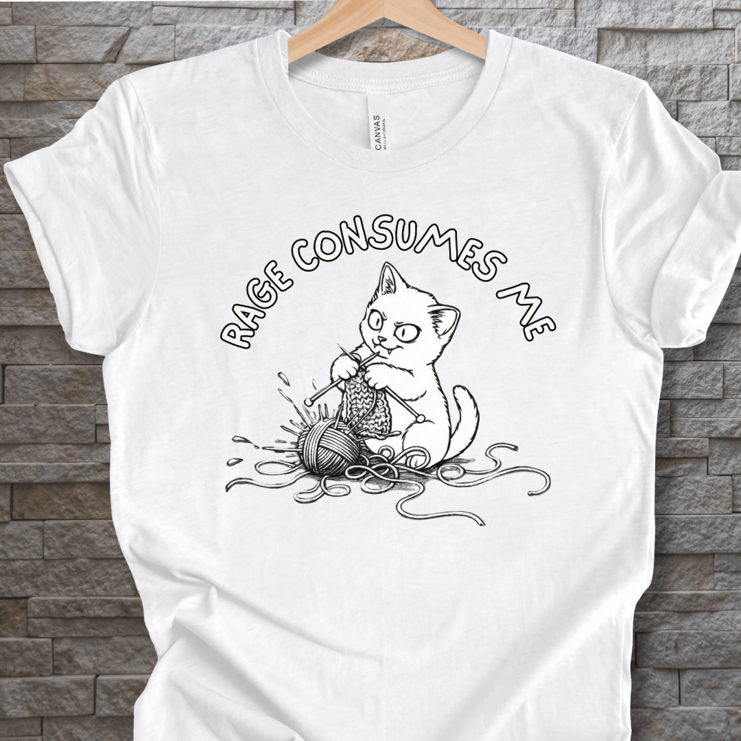 Funny white t-shirt featuring a cat knitting with the phrase 'RAGE CONSUMES ME' in black ink.