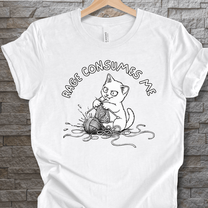 Funny white t-shirt featuring a cat knitting with the phrase 'RAGE CONSUMES ME' in black ink.
